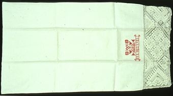 Örngott i linne med örngottshuva i knuten och trädd spets (filé) i ena kortsidan. Spetsens hela bredd är 300 mm, den är ihopsydd av två längder. Nätet är knutet diagonalt. En enkel hålsöm är sydd längs kanten innanför spetsen. Broderat monogram vid samma sida med korsstygn i rött med blommor, hjärtan, initialer och årtal: "MLH" (Malmöhus läns Hemslöjdsförening) och "1923". Örngottet är öppet i den andra kortsidan, stadkant längst ut. Handsydd vändsöm i ena långsidan, tygvikning i den andra.
Halvblekt linne vävt i tuskaft, 25 trådar/cm i varp och 23 inslag/cm. Nätet är knutet med och trätt med 2- och 3-trådigt lingarn. Korsstygn i rött, 3-trådigt bomullsgarn.