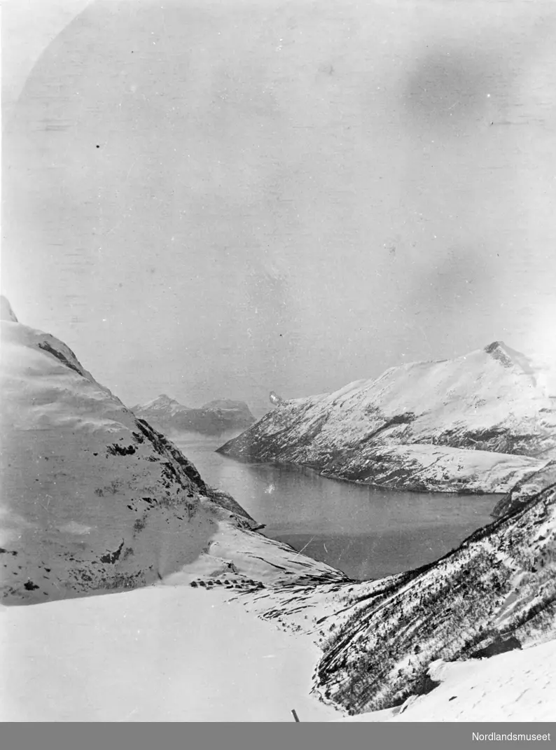 get. Bildet er tatt nedover bratt fjellside 20.mai 1917.Viser snødekt natur med noen hus/brakker langt nede 