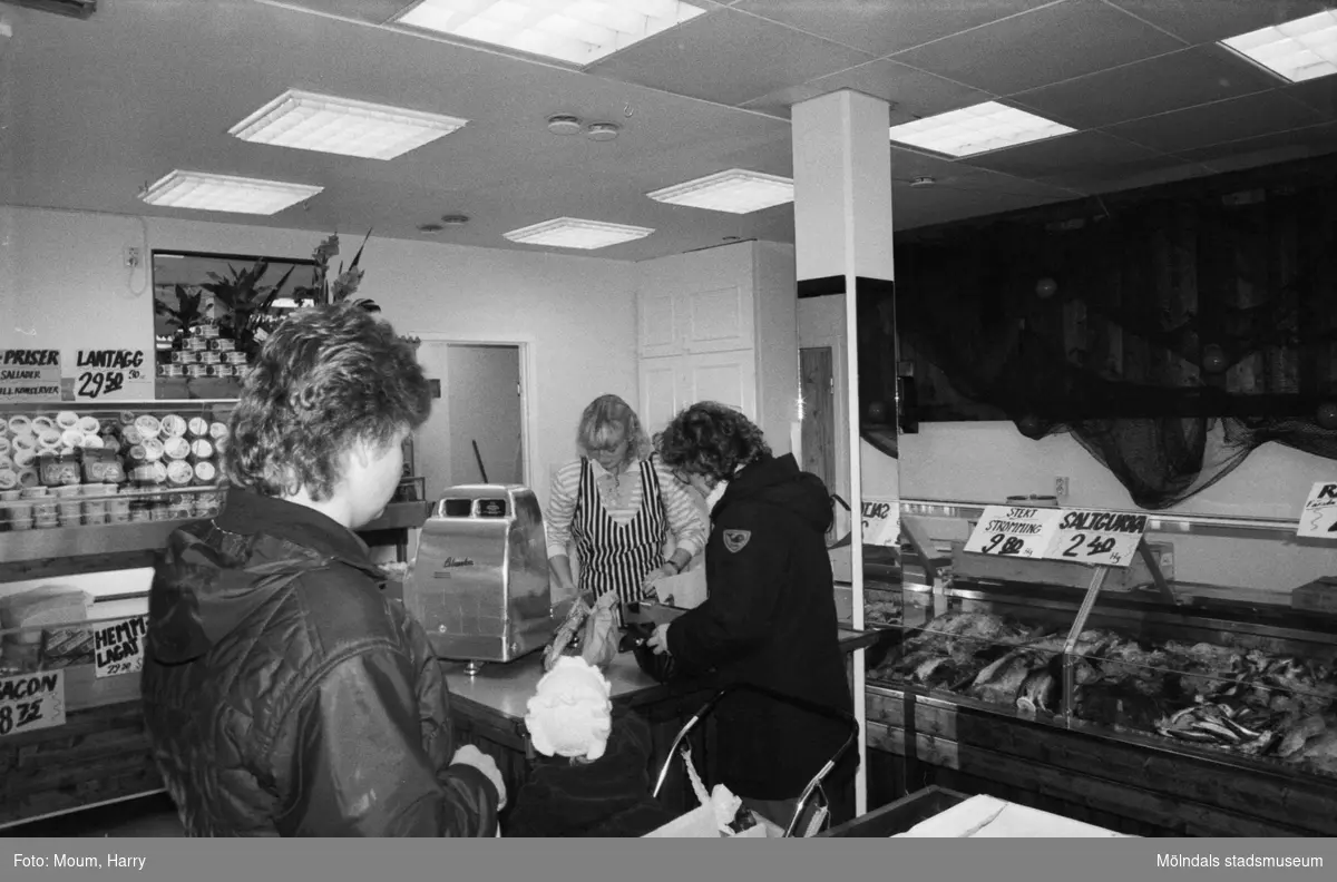 Ny fiskaffär, Fiskhörnan, på Hagabäcksleden i Kållereds centrum, år 1983. Christina Sjöbring betjänar kund.

För mer information om bilden se under tilläggsinformation.