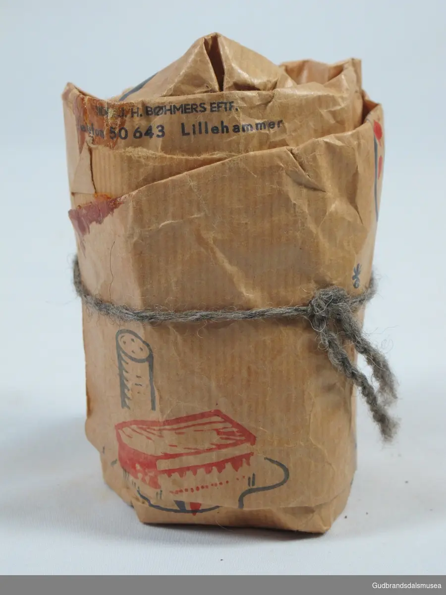 Papirpose med innhold fra Tidl. J.H.Bøhmers Eftf.
Posen har motiver i rødt og blått :
Malingspann i rødt og blått, blå palett med røde malingsklatter, blå pensler med rød bust.
Pakken er knyttet igjen med grå og sortspettet ulltråd.
