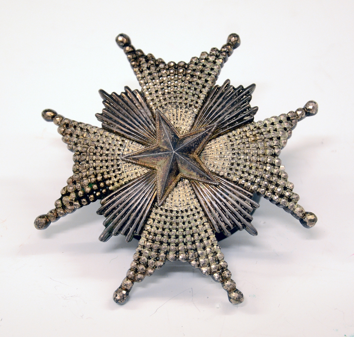 Nordstjerneordenens kommandørkors. 
"Nordstjerneordenen var før år 1975 tenkt som belønning for svenske og utenlandske "medborgerliga förtjänster, för ämbets- eller tjänstemannagärning, för vetenskaper, vittra, lärda och nyttiga arbeten samt för nya och gagneliga inrättningar". Ordenen utdeles nå bare til medlemmer av det svenske Kongehuset og til utenlandske medborgere eller statsløse, som har gjort personlig innsats for Sverige eller for svenske interesser. Ordenen bæres opprinnelig i et sort bånd, fra og med 1975 i et mellomblått bånd med gule kanter. Korset bærer ordenens ordtak "Nescit occasum" (Den vet ikke av noen nedgang). Gradene er: kommandør med store korset, kommandør, ridder av 1. klasse og ridder. Til ordenen hører en medalje - "Nordstjärnemedaljen" i gull av 8 forskjellige størrelser." (Avskrift/oversettelse av det svenske kongehusets nettsider.