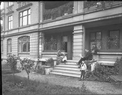 Familiebilde, mor, far og tre barn på hagetrapp