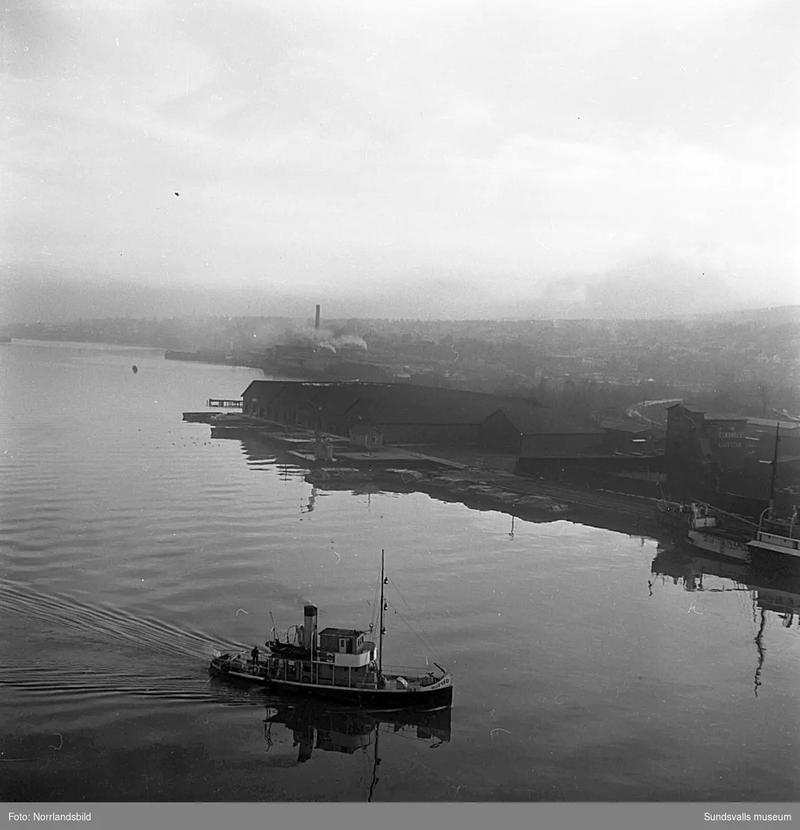 En serie bilder från verksamheten i hamnen i början av 1950-talet. Båtar, pråmar, kranar, kolhögar och magasin.