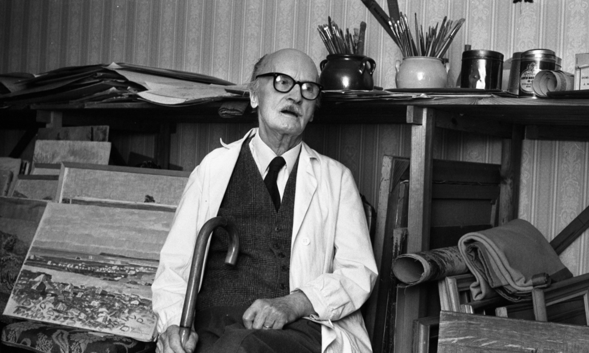 Frans Timén 30 december 1967

Konstnär sitter på en stol och håller en käpp i handen. Bakom honom ser man tavlor, och en bänk med krukor och penslar.