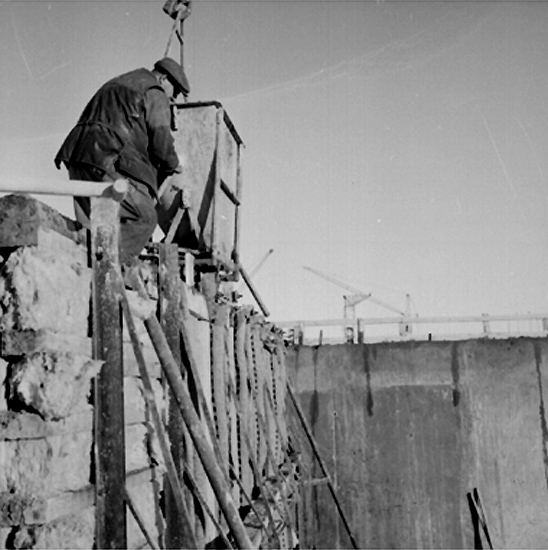 Byggnadsarbete, en man. Gjutning av väggform med betongbask.

Örebro söder.