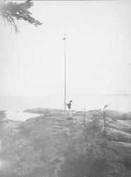 En mann fester eller løsner snoren til en vimpel eller et fl