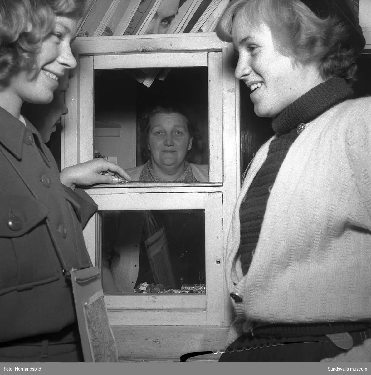 Fru Agda Eriksson vid kaffestugan i Sidsjön, som haft inbrott för åttonde gången. Tre oidentifierade flickor står utanför kioskluckan.
