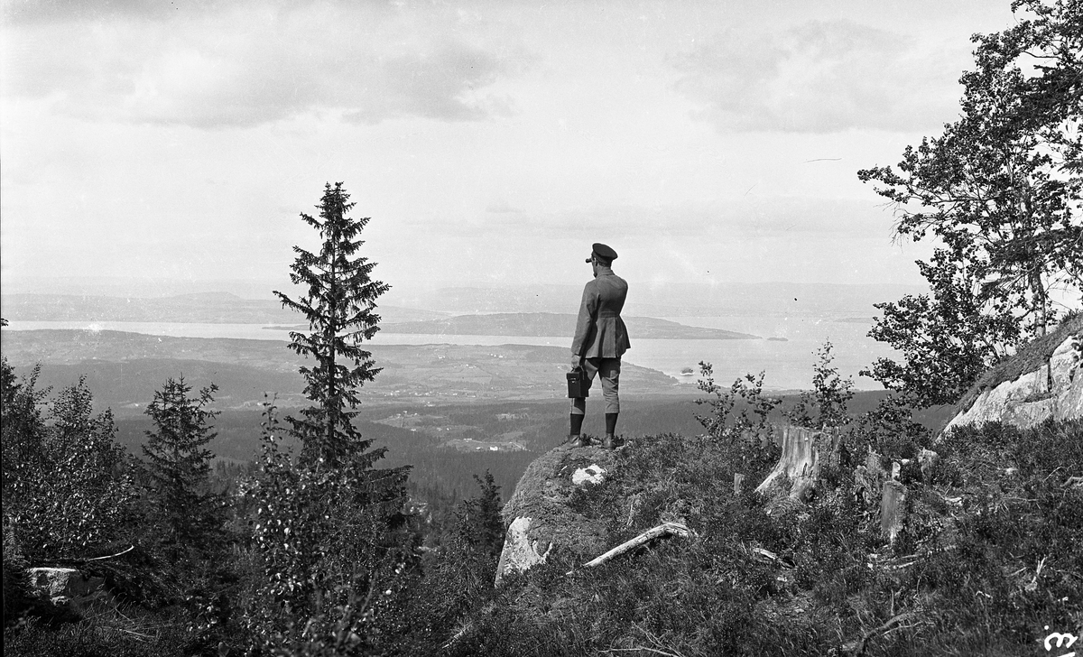 Sigurd Røisli nyter utsikten på Totenåsen. Utsikt trolig fra området nær Holokampen. To bilder, der det ene også får med seg Mjøsa.