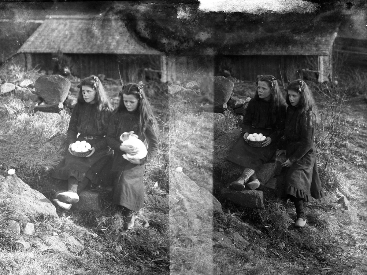 Barnporträtt. Fotografens två systrar Signe, med en kanin och Lydia med hönsägg på ett fat - symboler för påsken. 1910-tal.