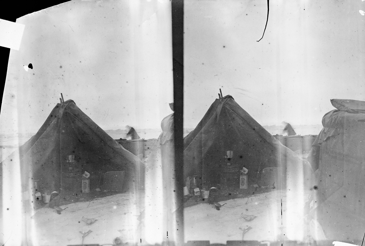 21 juli 1897. Stereobild. Lägret vid "Örnens" landningsplats. Till vänster gondolen, till höger tältet. Mellan dem skymtar båten. I tältet ses förutom proviant- och kokkärl en kokapparat och till vänster en proviantkorg. Framtagning av bilderna gjordes av docent John Hertzberg år 1930 på Fotografi, Tekniska Högskolan.
