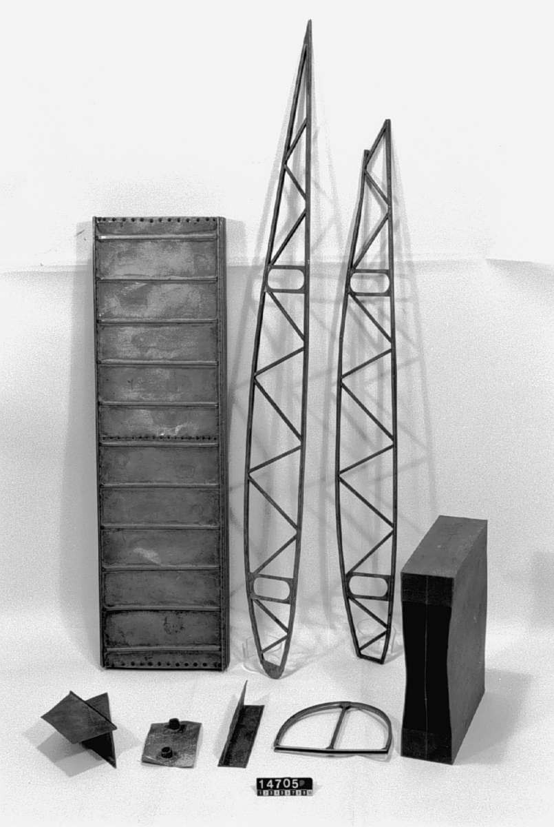 Ett antal prov på svetsade knutar av stålrör, nitade balkar av stålplåt m.m. till flygplan. Modell till balk i trä.