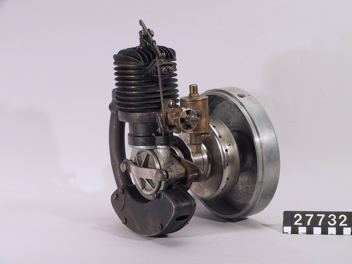 Omkring 1926. Hjälpmotor som var monterad på vänster sida av framhjulet och drev på framhjulets nav. En planetväxel växlade ner motorns varvtal till framhjulets. Klafftändning i cylindern och lågspänningsmagnet i svänghjulet. ÖWA förgasare. Hjul, bensintank, reglage och förstärkning för cykelns framgaffel saknas. Cylinder/motornummer 3079.  Encylindrig luftkyld tvåtaktsmotor, cylindervolym 83 cc Cylinderdiameter: 51 mm. 2 hk vid 3 500 varv/minut Högsta fart 40 - 50 km/timmen