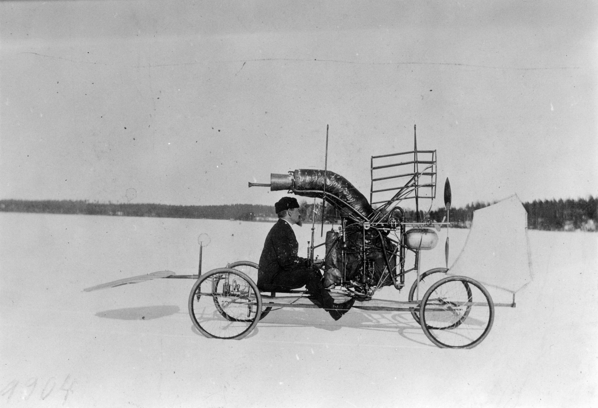 C. R. Nyberg i sin flygmaskin utan vingar för provning av maskinen. Hela maskineriet synligt. Nyberg i maskinen år 1904.
