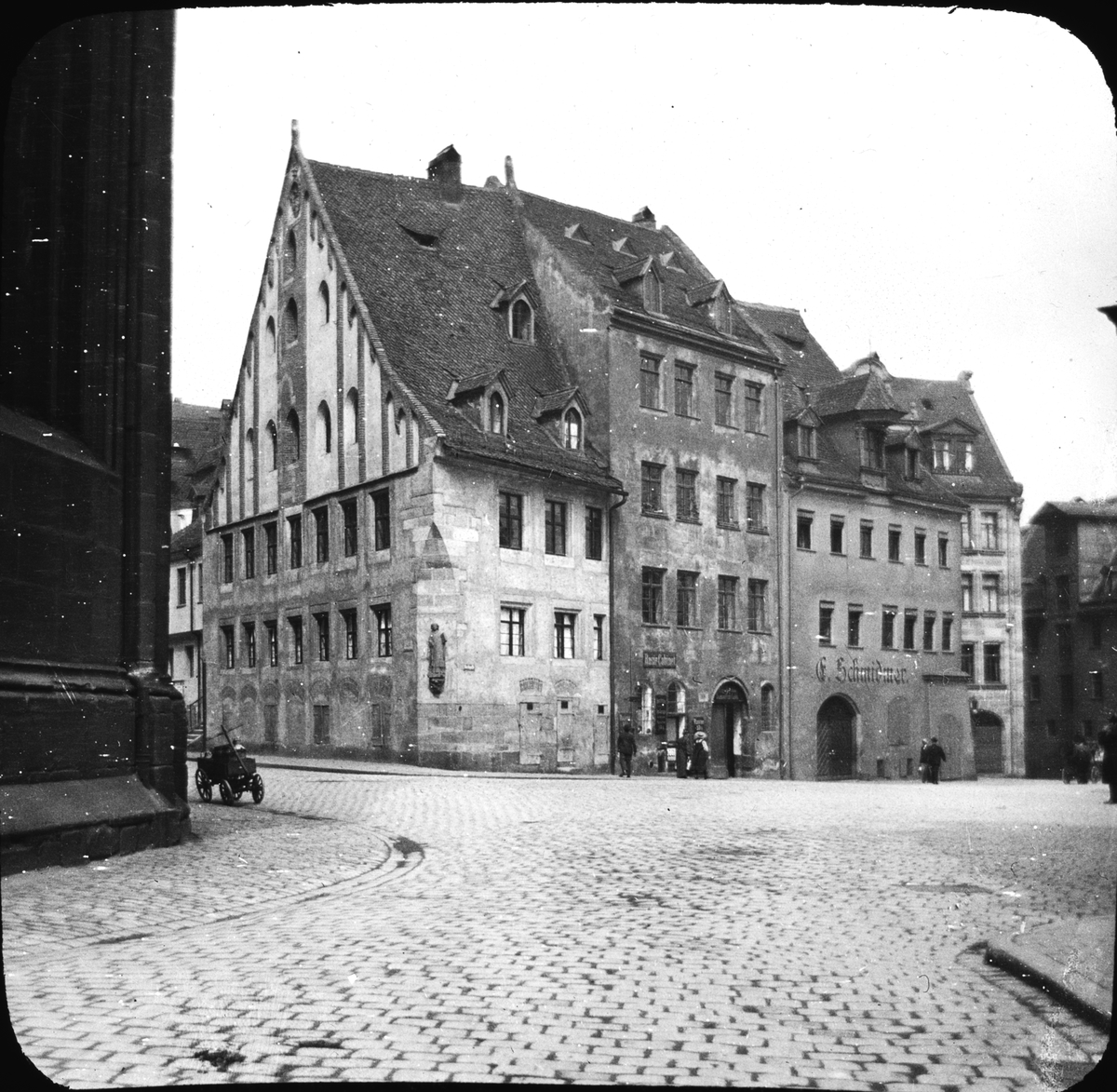 Skioptikonbild med motiv från Lorenzer Platz, gamla Lorenzer Latinskolan i Nürnberg.
Bilden har förvarats i kartong märkt: Resan 1906. Nürnberg.