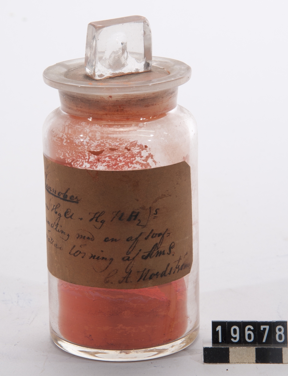 Prov på syntetisk cinnober, i burk av glas med etikett med beskrivning signerad C.A. Nordström.