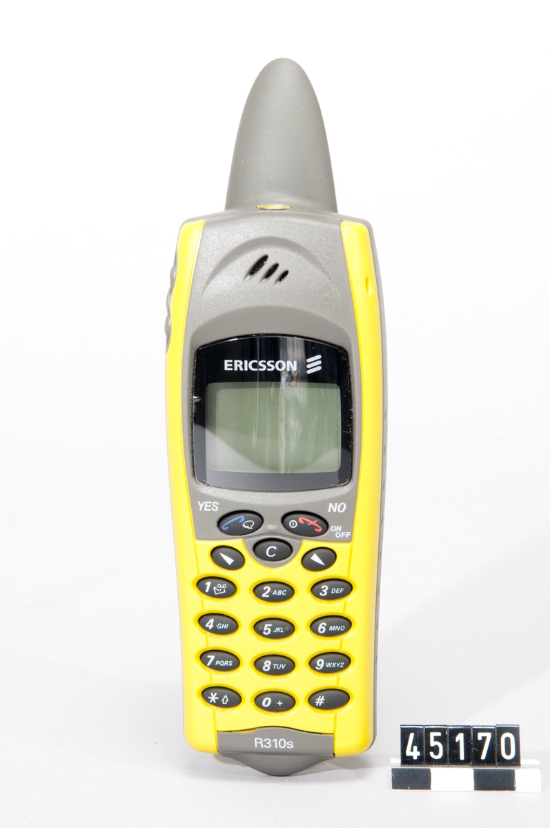 Mobiltelefon Ericsson R310 Marina i originalförpackning, kallat "floating pack". Den vattentäta förpackningen var tänkt att kunna användas som förvaring i våta miljöer. Kulör: Peak Yellow. Obegagnad.