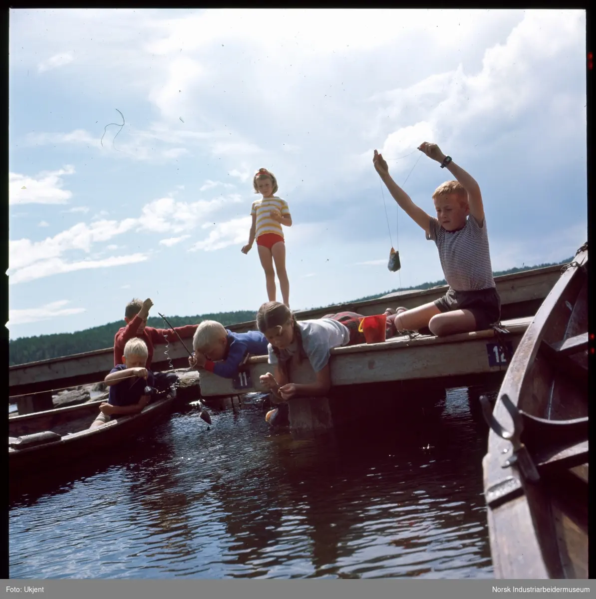 Hydrostranda. Barn fisker ved båthavna.