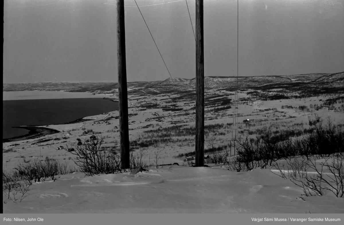 Vinterbilde  tatt fra Abelsborgfjellet med flott utsikt innover Meskfjorden (indre del av Varangerfjorden). Kanten på fjordisen har lagt seg ved Meskelv. 1967