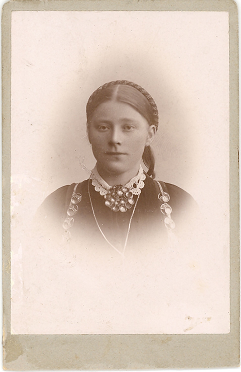 Brystbilde av yngre kvinne i beltestakk: Gunhild Johnsdotter Sisjord. f. Kåsa (Midtbø)