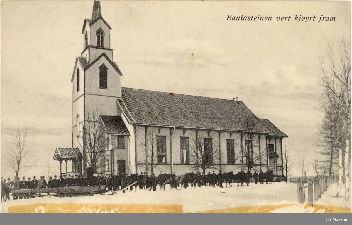 Bø kyrkje med folk og hestar som trekker ein stor bautastein.
