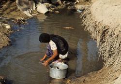 Kvinne vasker klær.