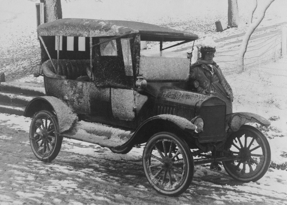 Fordbilen med chaufför i en snöstorm i Gränna.