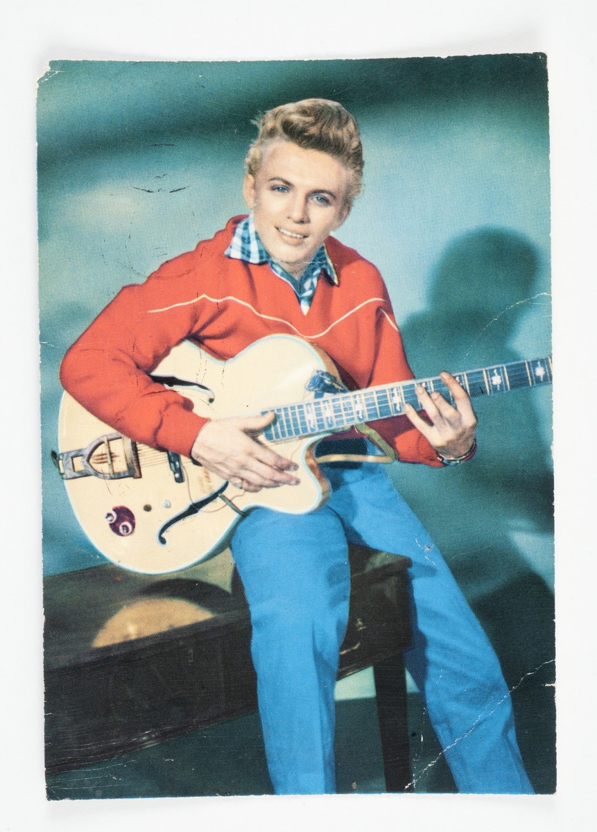 Foto av sittende gutt med gitar