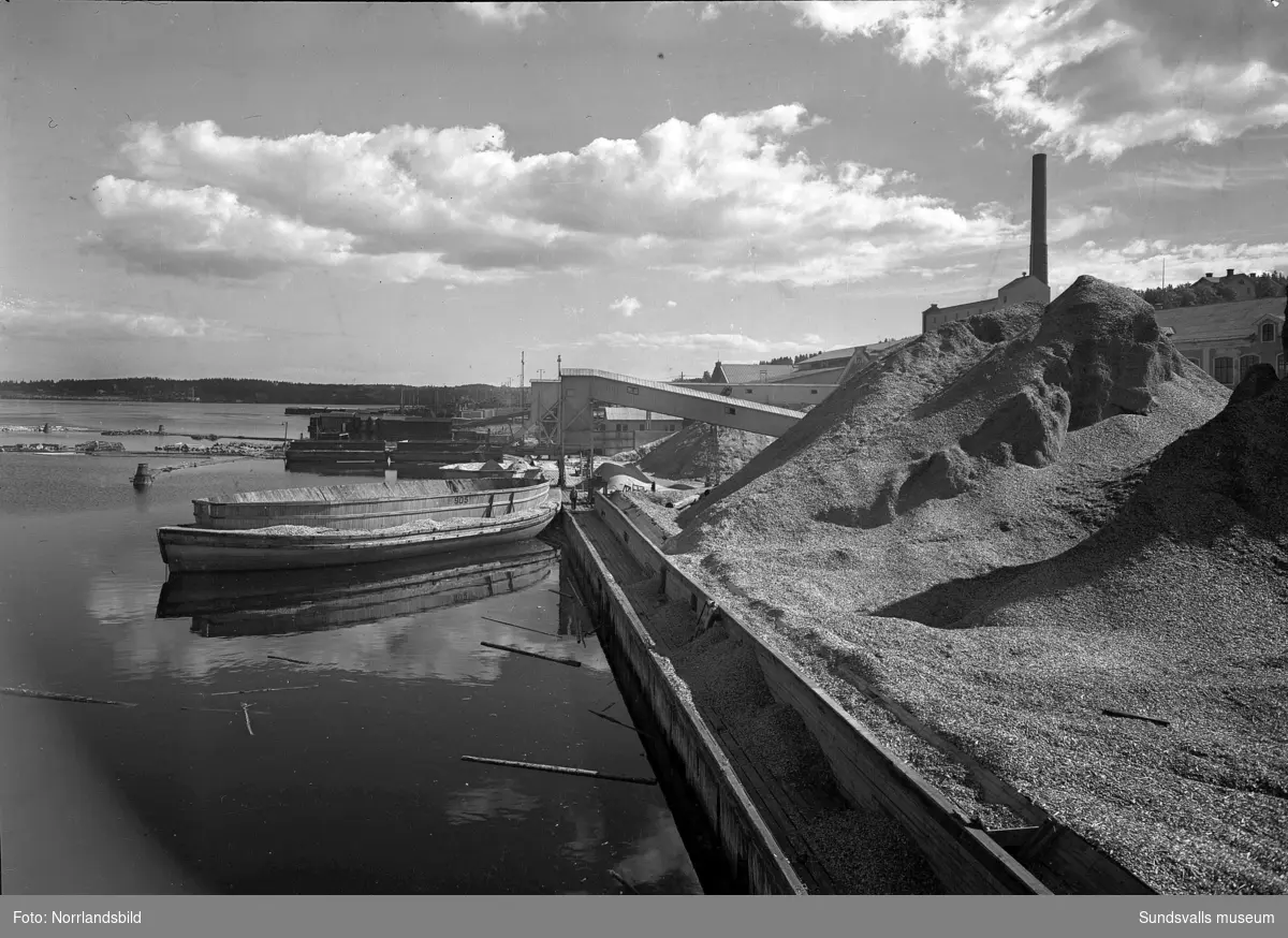 En stor grupp bilder från Skönviks sågverk. Översiktsbilder, interiör- och exteriörbilder från verksamheten, pråmar, lastning på fartyget Aquila, kontoret med mera,