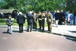 Landskap. En gruppe personer, deriblant noe uniformerte, pla