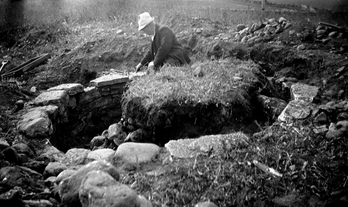 Utgrävning av varggrop med intilliggande skelettgrav juni 1934. Varggropen består av stensatt grop där väggarna kallmurats. Gropen har senare fyllts med odlingssten.