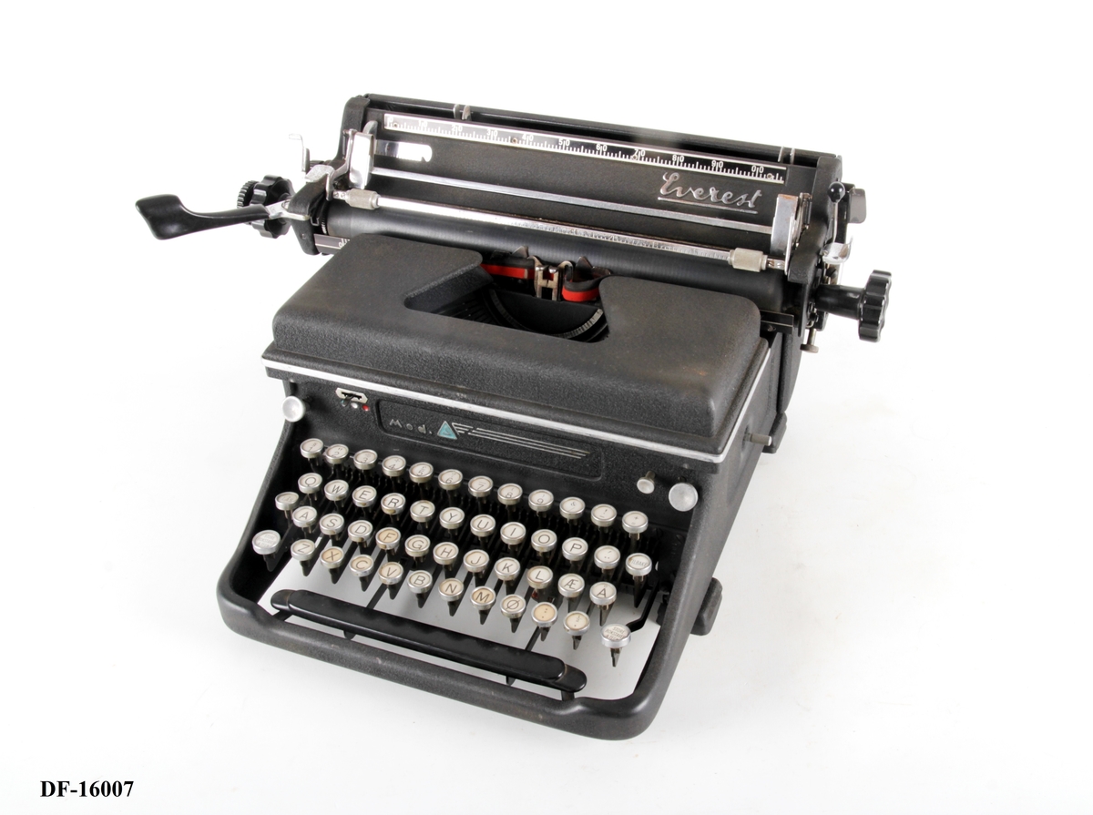 Manuell skrivemaskin med skrivevalse og fargebånd med to farger (svart og rød).