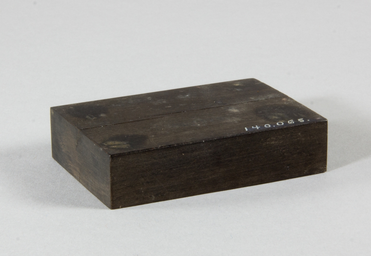 Rektangulär platta av trä, ebenholts. Möjligen del av brevpress.
