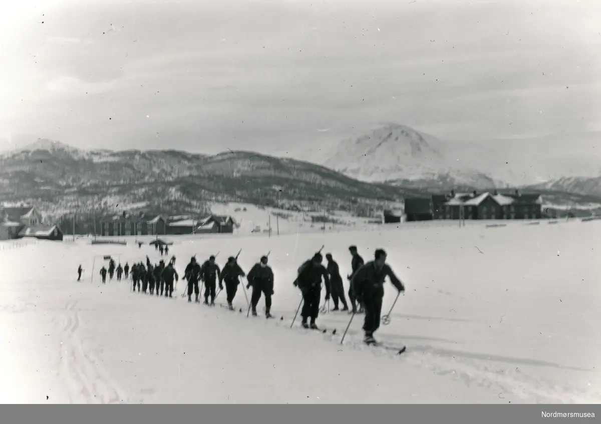 Soldater som går på ski langs et skispor.