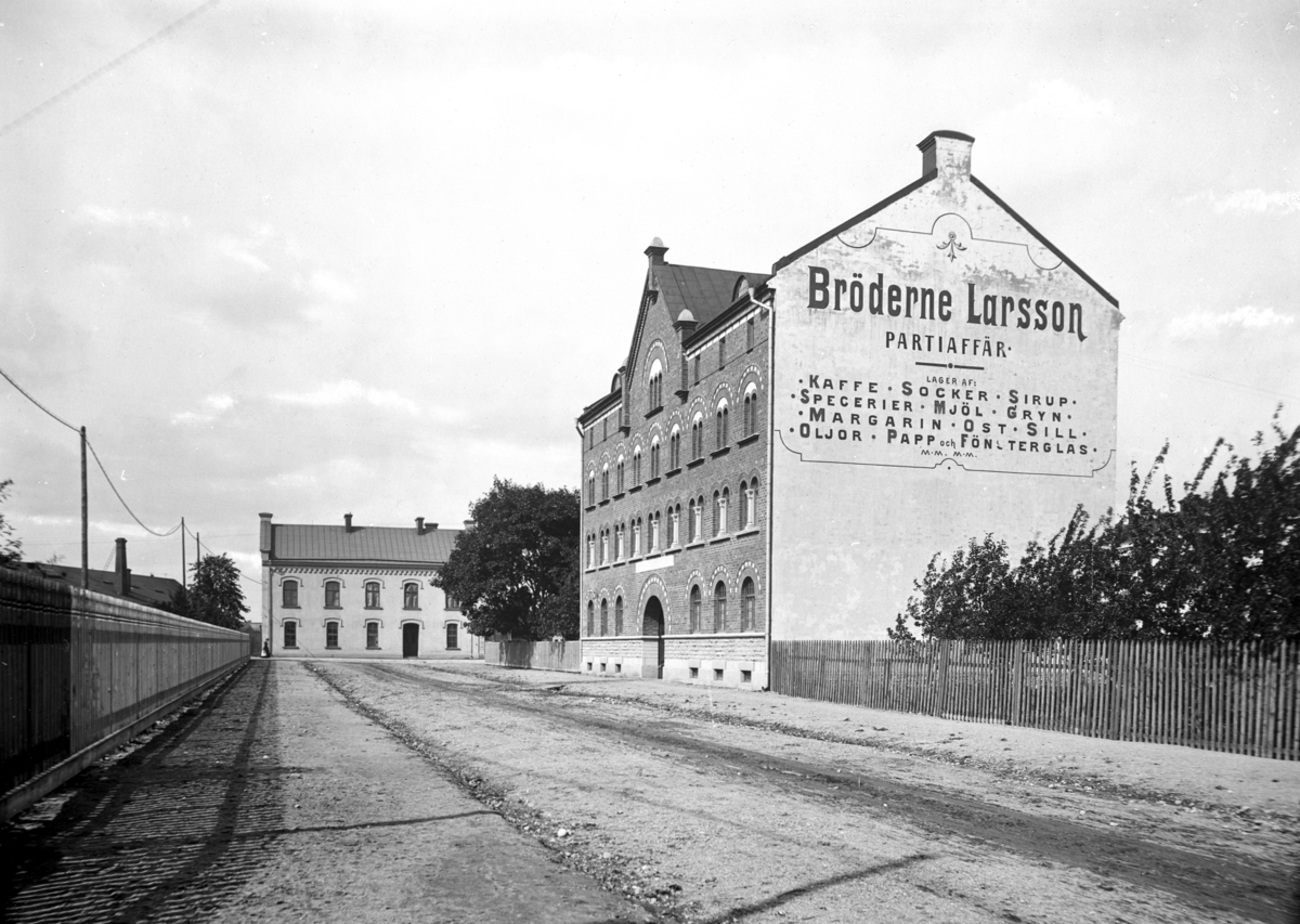 Fyra vånings stenhus, Bröderna Larssons Partiaffär. 
Norra Grev Rosengatan västerut mot Storgatan.
Bilden är troligen tagen 1903 av Axel Barr (Reproduktion 1934).