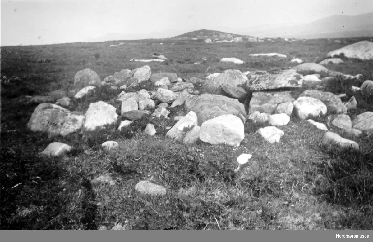 Bilde av en gammel gravrøys på Valen, Edøy, med et gravkammer. Se Yderstads notater Nr. 1. Bildet er datert Juni 1948, og trolig den 16. i den måneden. Nordmøre Museums fotosamling