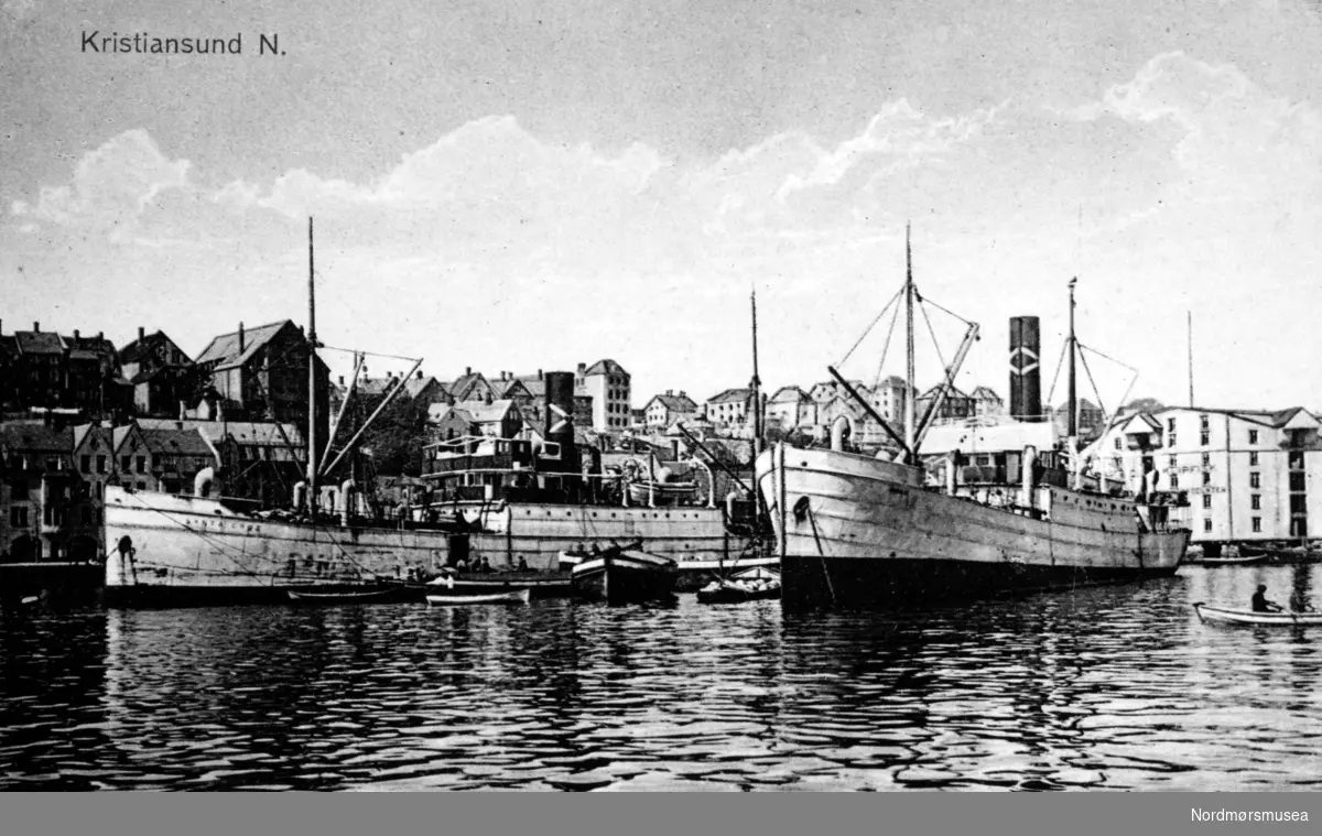 Postkort: ";Kristiansund N."; Foto av to frakteskip i Johnsenhuken. Antageligvis av utenlansk opprinnelse, da fartøyet til venstre trolig bærer navnet ";Santa Eniz";. Datering er ukjent, men trolig omkring 1910 til 1929. Fra Nordmøre museums fotosamlinger. /Reg:EFR2013/
