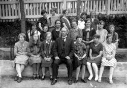 Foto av to kvinner, tre piker og en gutt sittende ved et mat