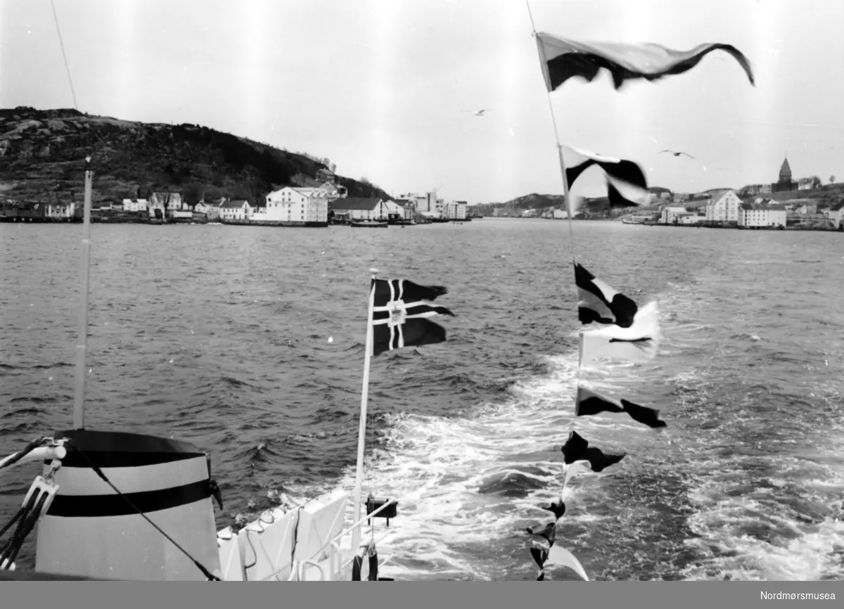 Bildet viser overleveringsturen ut på Bolgsvaet gjennom Marcussundet i Kristiansund med B/F”Norddalsfjord” Storviks Mek. Verksteds bnr. 14 til Møre og Romsdal Fylkesbåtar. 
”Norddalsfjord” ble levert til Møre og Romsdal Fylkesbåtar 15. mars 1961 og hadde følgende hoveddimensjoner: L 31,20 m x B 8,55 m x D 3,35 m og hadde en tonnasje på 159 bruttoregistertonn. Fremdriftsmaskineriet består av 3 Volvo Penta turboladede dieselmotorer type TMD96 på til sammen 420 hk som via kilremdrift var koblet til et felles gir og propellaksel med vribar propell, slik at hver enkelt av motorene kunne kjøres separat. Fergen hadde 2 Bolinders vekselstrømsaggregater type 1052MG på 23 hk hver tilkoblet en generator på 17 kW. Fergen var utstyrt med elektrohydraulisk styremaskin.
Fergen har plass til 18 personbiler og har sertifikat for 160 passasjerer. Forut er det innredet 6 lugarer for offiserer og restaurantpersonale og akterut en mannskapslugar for 4 personer og toppfarten er 11,4 knop og marsjfarten 10,5 knop.
Til venstre i bakgrunnen ses Innlandet med bryggene og til høyre Nordlandet med kirka.
Ferga er verkstedets første nybygg etter B/F”Trygge” som ble levert i 1938. (Info: Peter Storvik). --
Fra hekken,  jomfruturen med ei ferge, her på vei ut til Bolgsvaet via Markussundet i bakgrunnen. Til venstre ser vi Innlandet og til høyre Nordlandet. Legg merke til postflagget. Fra Nordmøre Museums fotosamlinger. Tilleggsopplysning: B/F Nordalsfjord, bygg nr.14 ved Storvik mek. Verksted A/S, levert 1961. Med signalflaggene heist opp tilsier det er jomfruturen etter dåpssereminien og overleveringen fra byggeverftet til rederiet. (Informant: Ar.H / Norsk Skipsfartshistorisk Selskap Nordmøre.





)