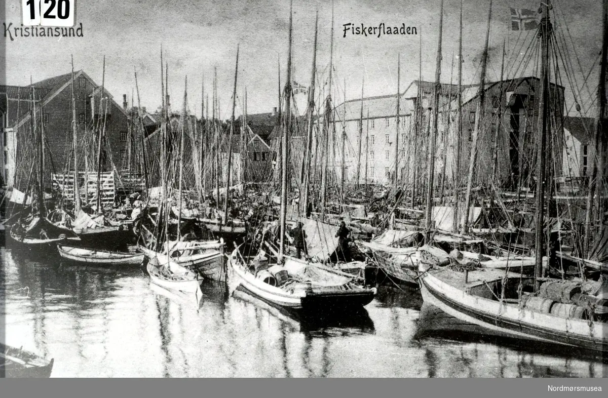 "Kristiansund" og "Fiskerflaaden" Postkort med motiv fra et fullpakket havneområde i Johnsenhuken ved Astrupbryggen i Vågen på Kirkelandet i Kristiansund. Bildet som trolig er fra omkring 1890 til 1900 viser lag på lag med seilskip. Fra Nordmøre Museums fotosamlinger.