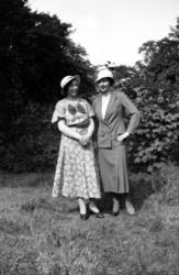 Fotografi av to kvinner i en hage. Kvinnen til venstre er sa