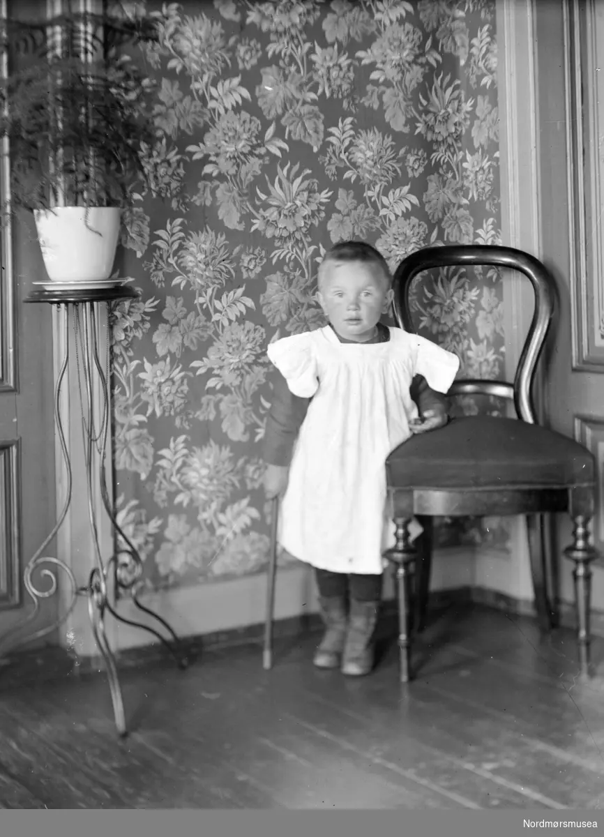 Portrett av et lite barn. Barnet er trolig fra Sverdrupfamilien/slekten, og bildet er trolig fra Rosentræders gate 1 på Kirkelandet i Kristiansund, Fra Nordmøre Museum sin fotosamling. EFR2015