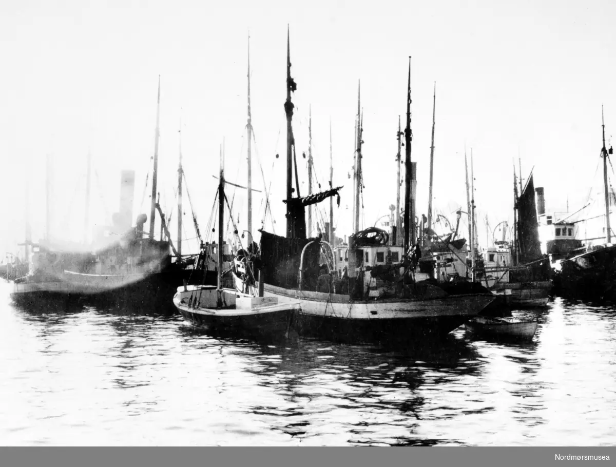 Foto fra Anders Beer Wilses fotoarkiv, hvor vi ser fra deler av fiskeflåten i Kristiansund. Fotoet er trolig fra perioden rundt 1910-1930. Fra Nordmøre Museums fotosamlinger.
