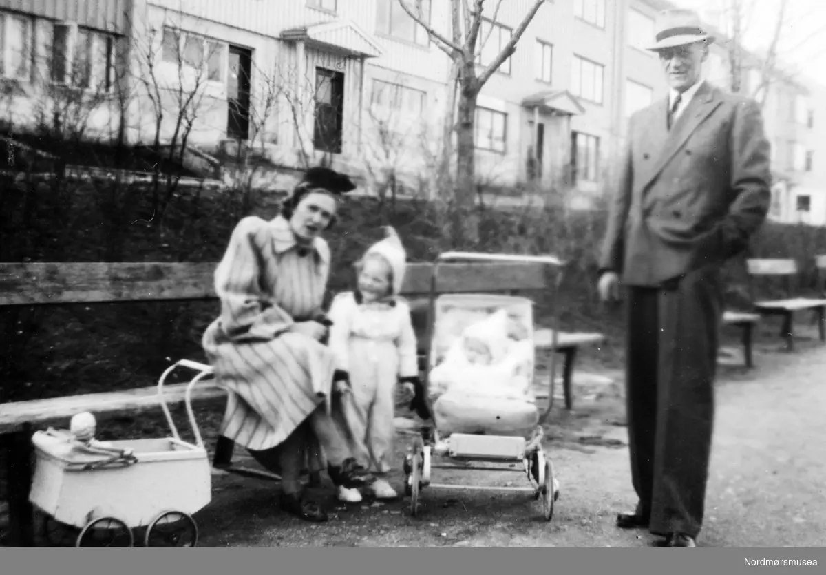 Foto av en familie. Bildet er trolig tatt i parken ved Konsul Johnsens gate på Kirklandet i Kristiansund.  Kan dette være politimannen Trygve Løkke med hustru og barn? Fra Nordmøre museums fotosamlinger. EFR2015