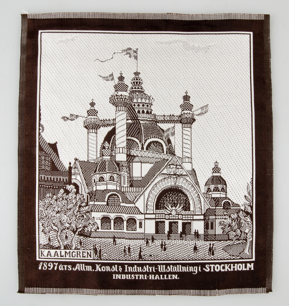 Näsduk av mönstervävt siden i brunt och vitt med text: "1897 års Allm. Konst & Industri-Utställning i STOCKHOLM, INDUSTRI-HALLEN". Signerad K. A. ALMGREN.