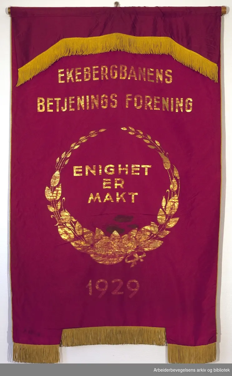 Ekebergbanens betjenings forening..Bakside..Fanetekst: Ekebergbanens Betjenings Forening.Enighet er makt.1929