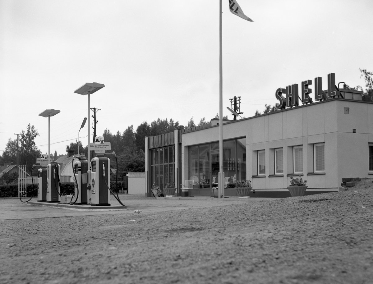 Någonstans i Värmland - från slutet av 1950-talet. Kommentar från användare: "Bilden är troligen från Shell macken i Grums. Jo det bör vara Shellmacken som fortfarande finns kvar. Till vänster byggdes senare Domus stormarknad som i sin tur senare blev gymnasieskola".