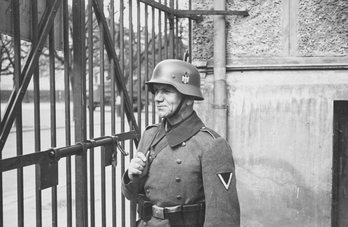 Norsk fangeleir  ved Logen i mai 1940. Tysk vakt ved porten.