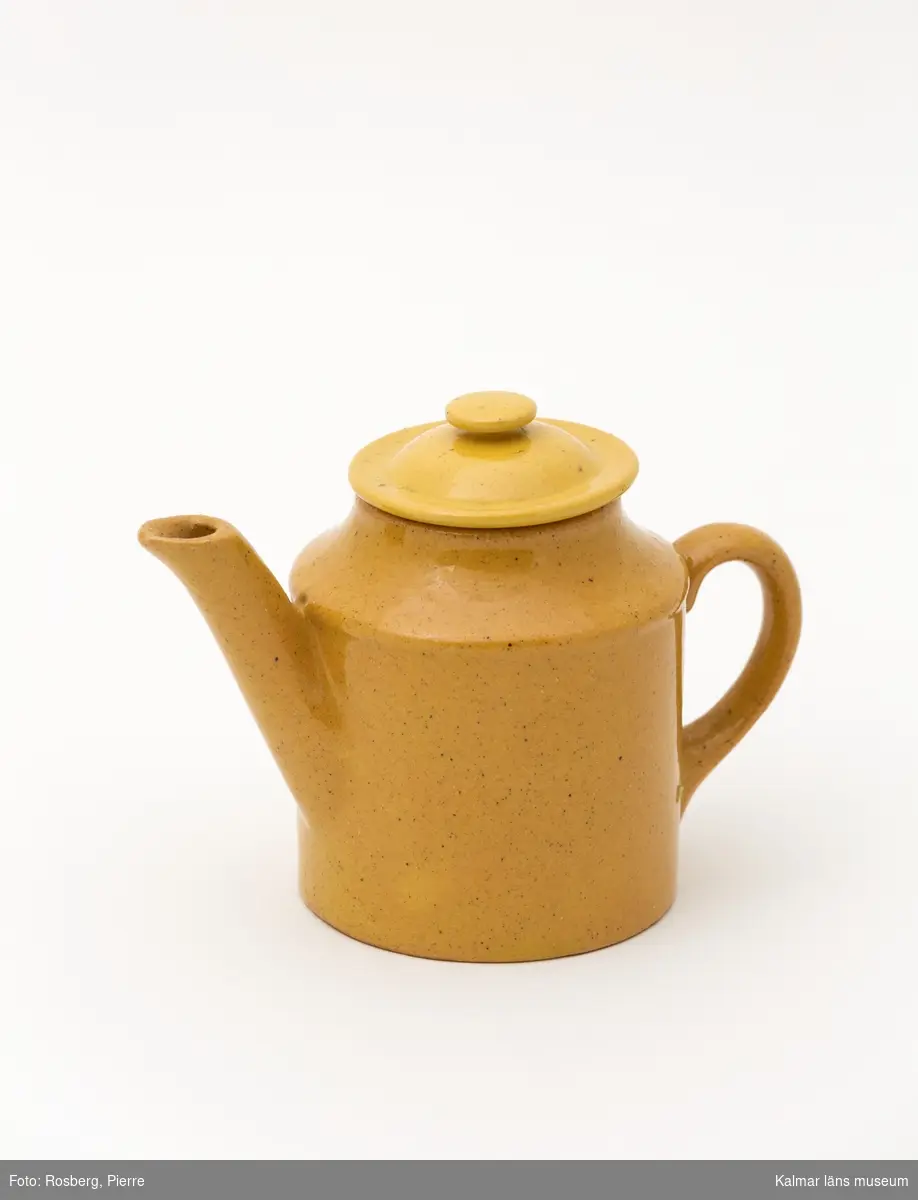 KLM 9792:2 Kanna, kaffekanna med lock. Av gult lergods, glaserat. Något ljusare gul ton på locket. Ingår i servis av lergods. Leksaksservis. Ostämplat. Tillverkat vid någon av Tillingegruppens fabrik under 1800-talets senare del.