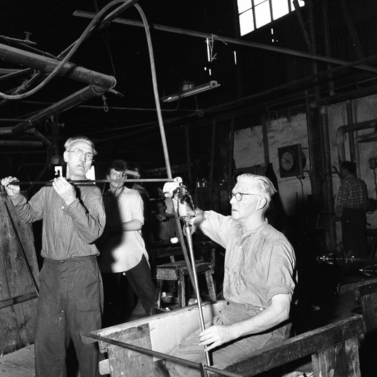 Flera män som arbetar i en glashytta.