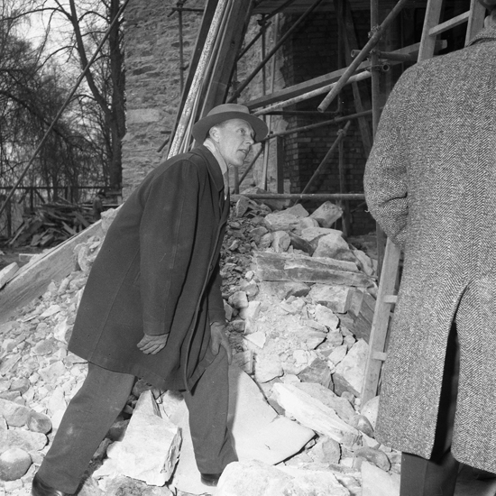 Växjö domkyrka, urtagning av runstenen ur domkyrkokorets östra gavel. 
Sven B.F. Jansson inspekterar runstenen. 1959.